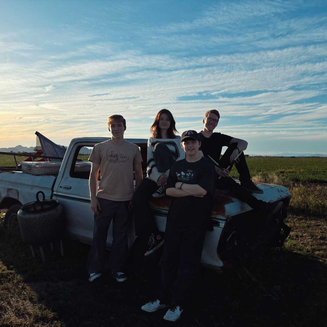 Friends standing in front of an old pickup truck